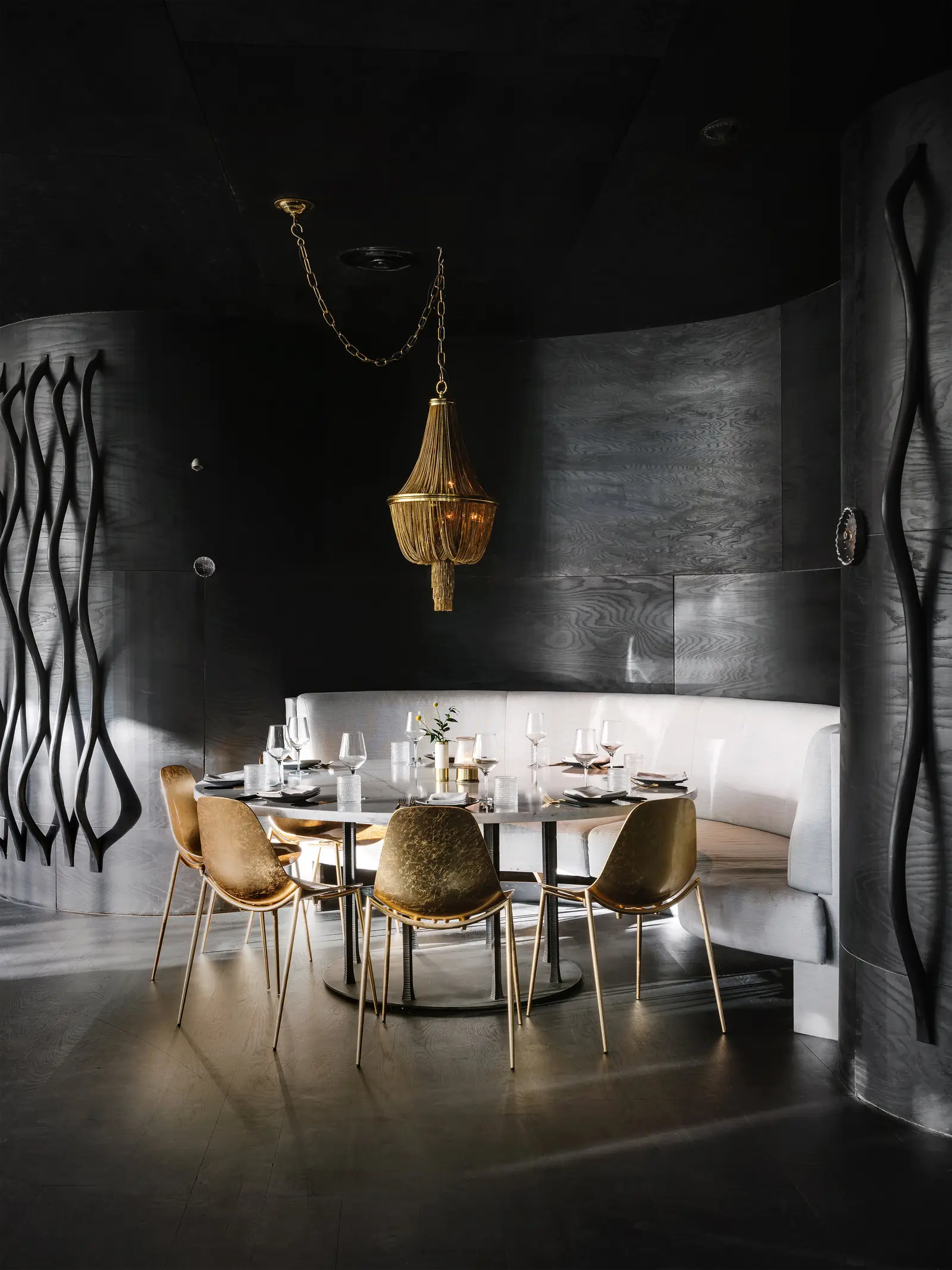 Line Hotel round private dining room with dark curved walls and gold chairs