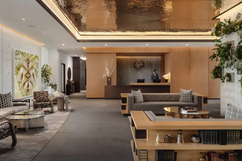 Loren Hotel hotel lobby with a wood reception desk, lounge seating and a metallic ceiling feature