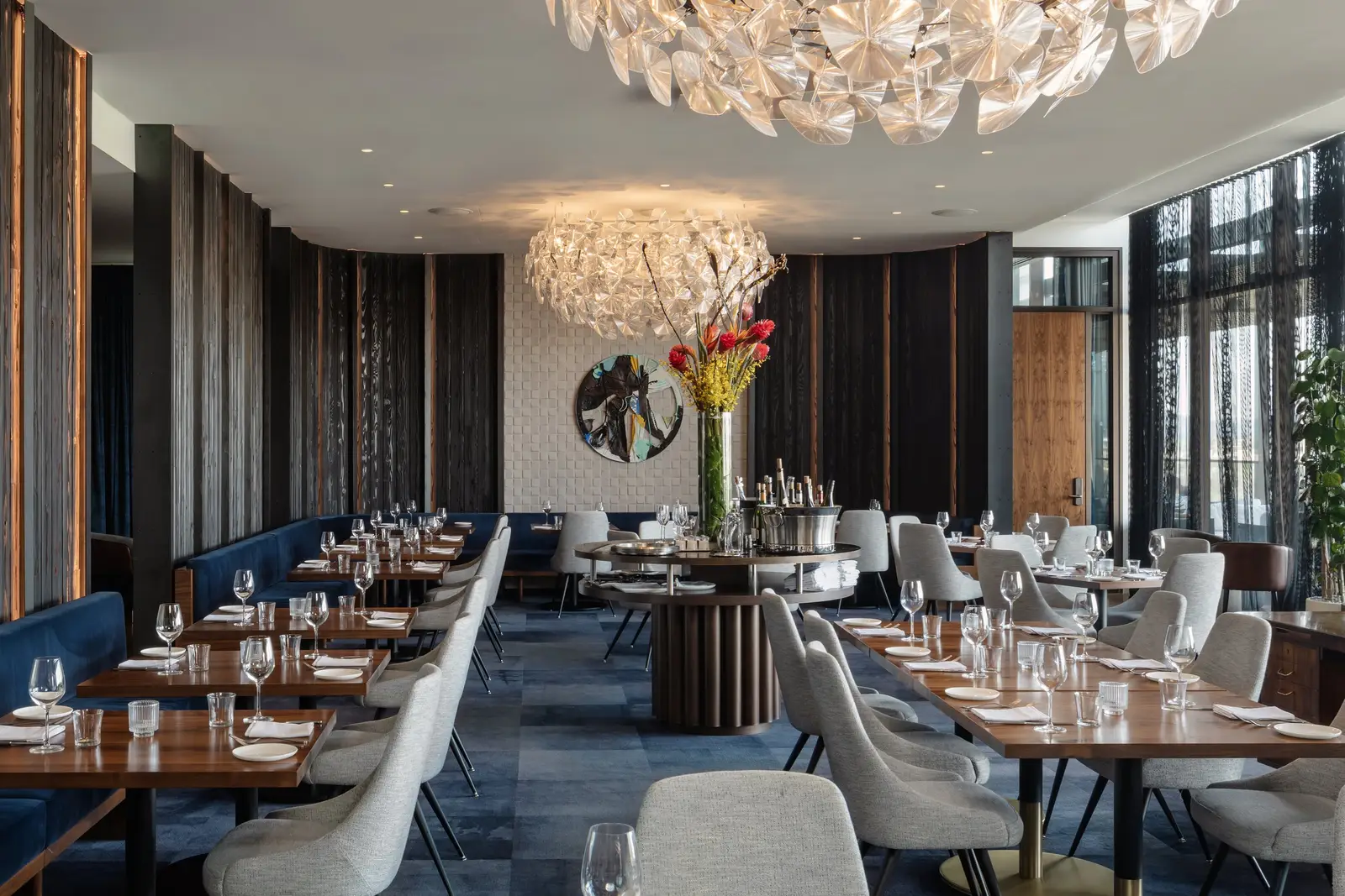 Loren Hotel hotel restaurant with a large chandelier, wood tables and blue chairs