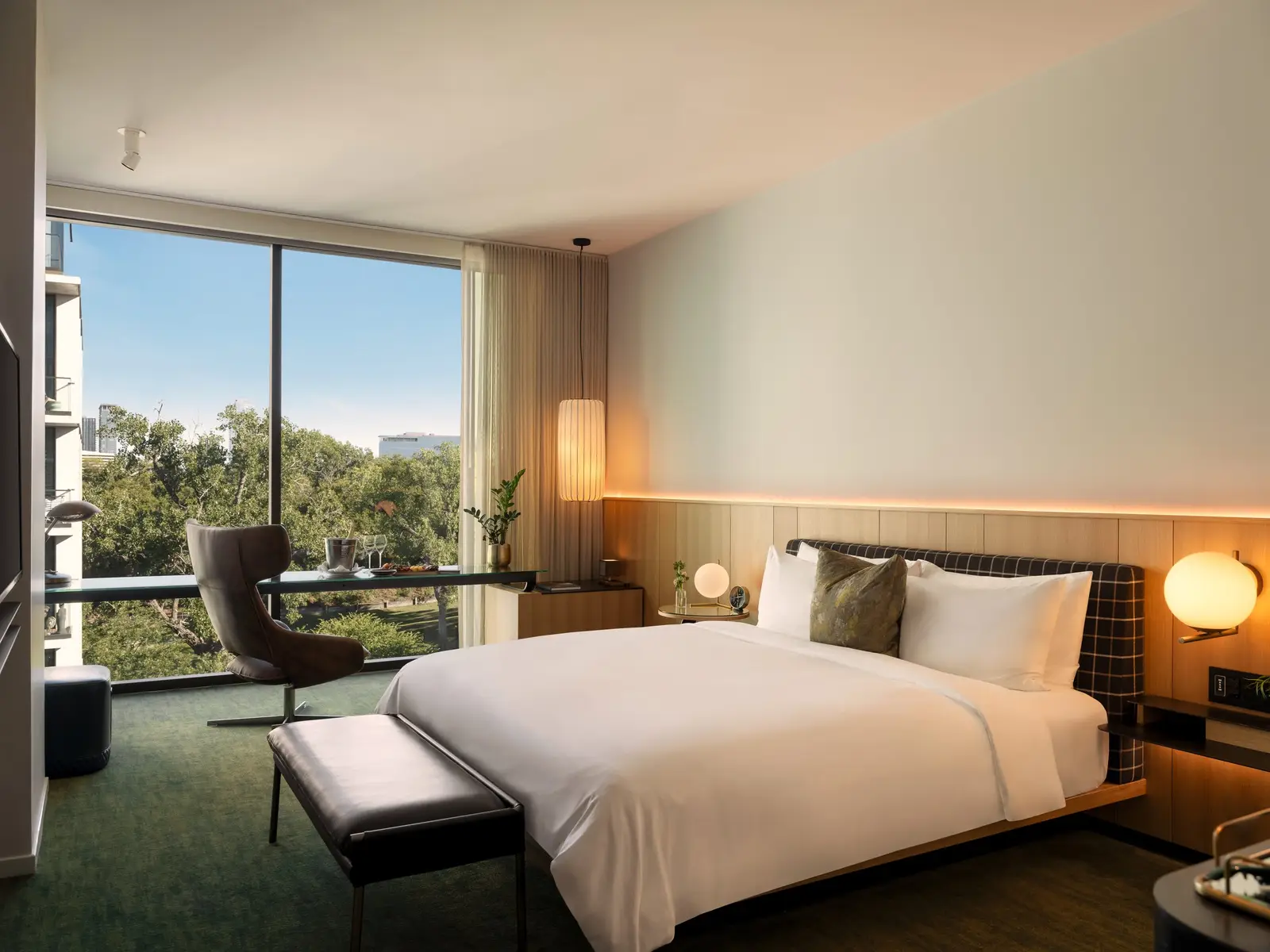 Loren Hotel guest room with a bed, wood headboard wall and a large window
