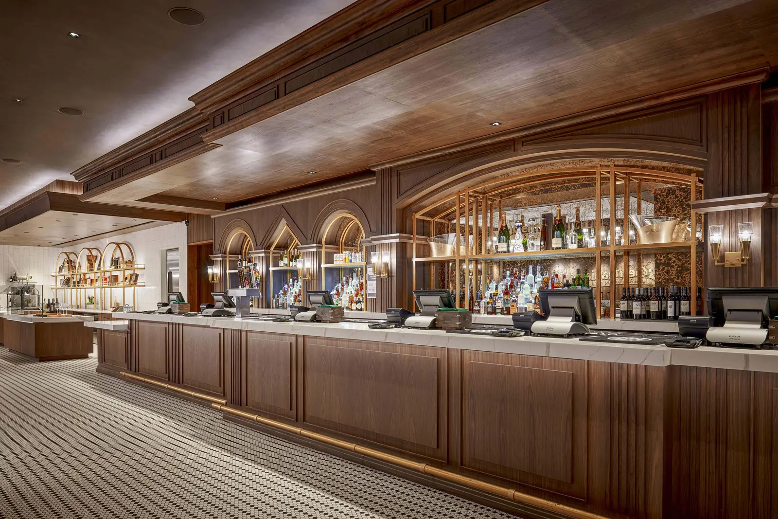 Moody Center club bar with a wood-front counter, arched back-bar shelves and a wood ceiling