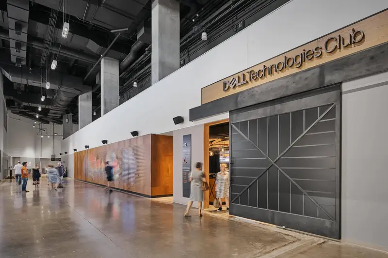 Moody Center club entrance with a black metal door and a wood-clad wall