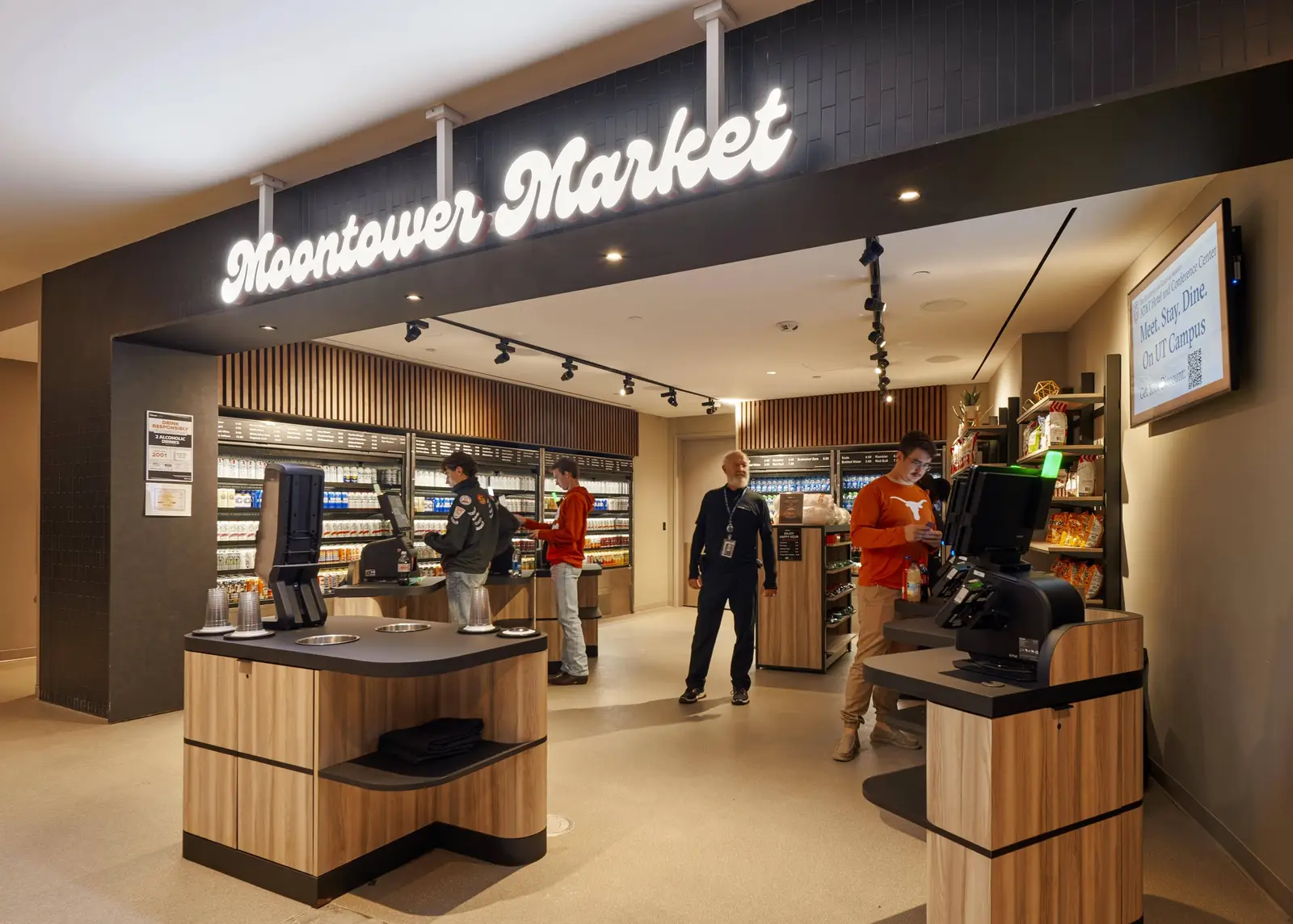 Moody Center concession market with wood counters and lit signage
