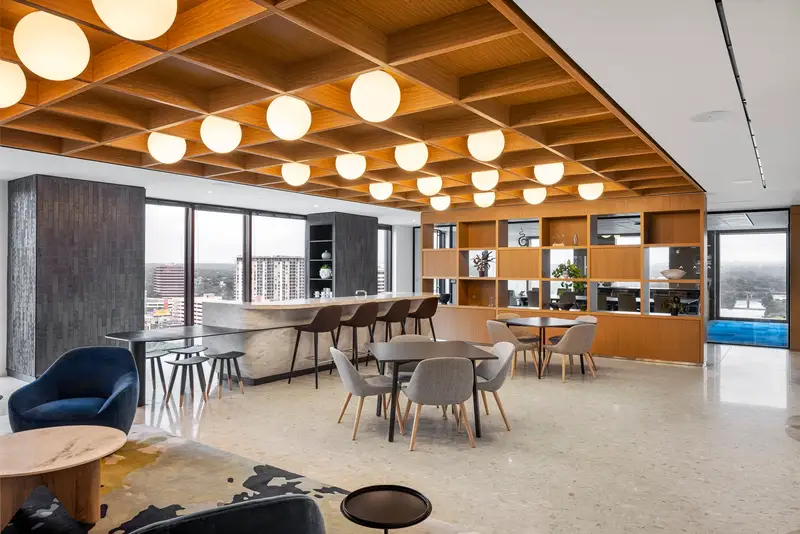 Norton Rose Fulbright office lounge with a wood coffered ceiling, round pendant lights and open shelving