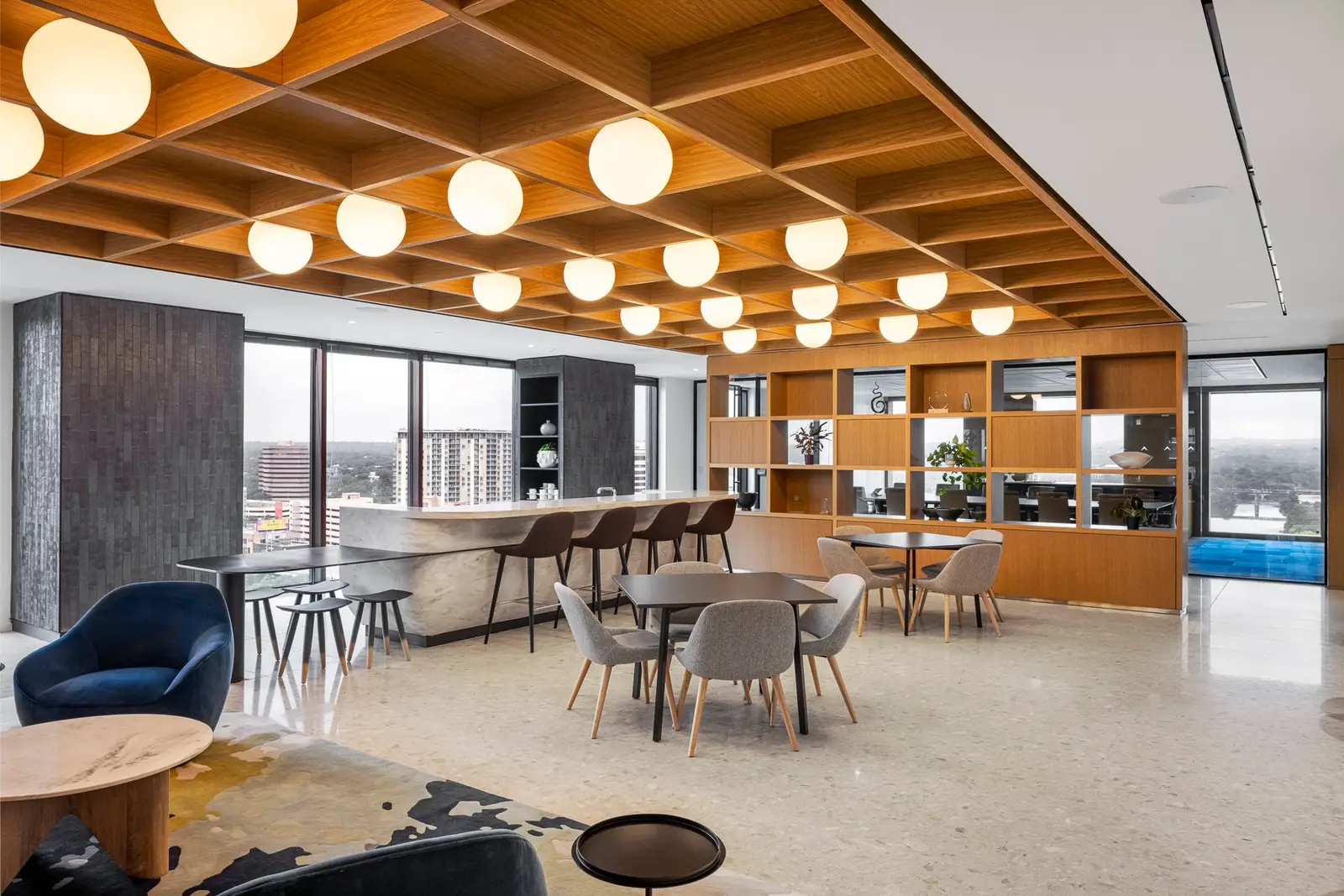 Norton Rose Fulbright office lounge with a wood coffered ceiling, round pendant lights and open shelving