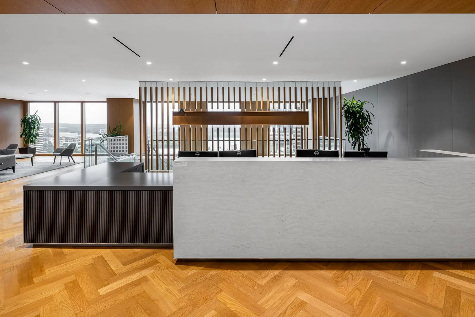 Norton Rose Fulbright reception desk with a stone front and a vertical wood slat screen behind