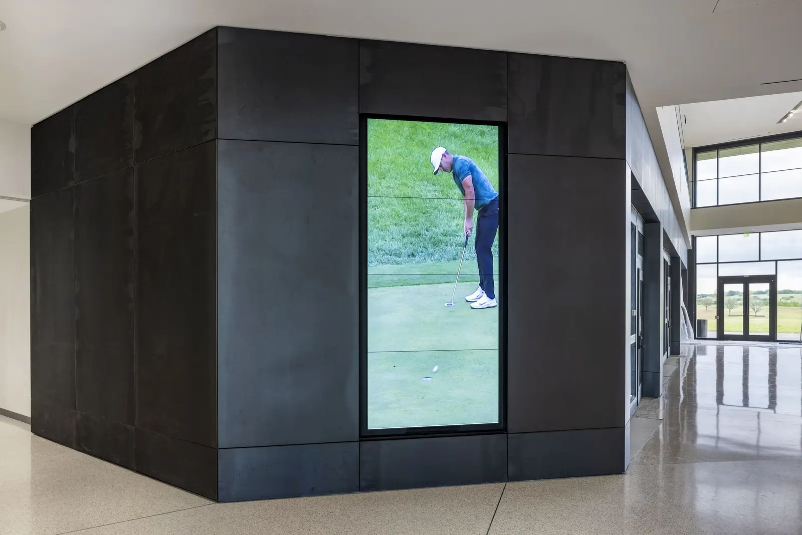 PGA of America dark metal-clad volume with a screen showing a golfer putting