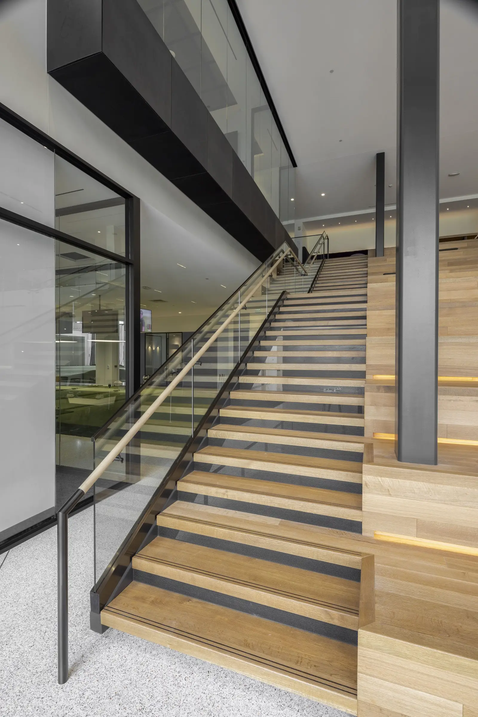 PGA of America wood stair with a glass guardrail and metal supports