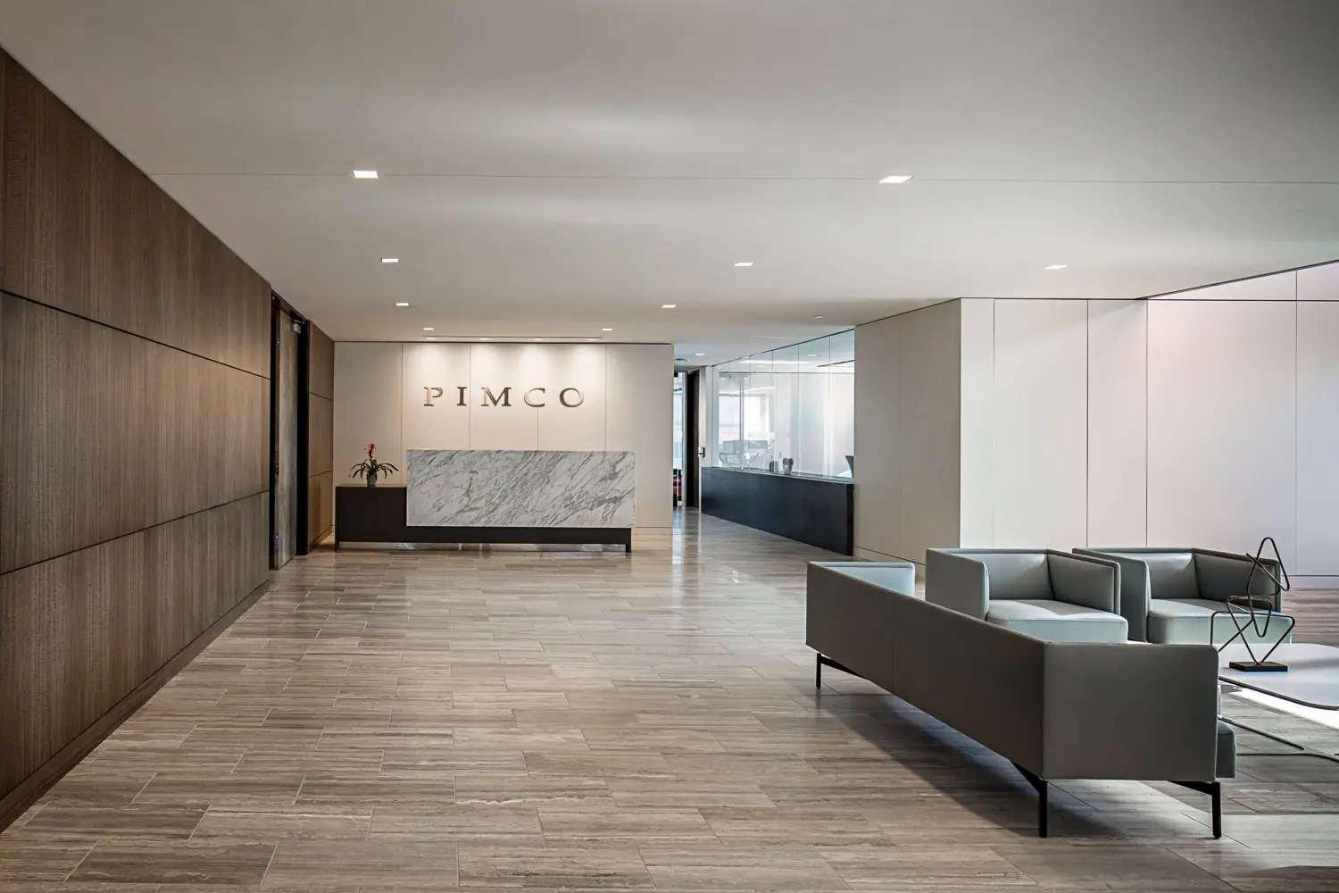 PIMCO reception with a stone-front desk and wood wall panels