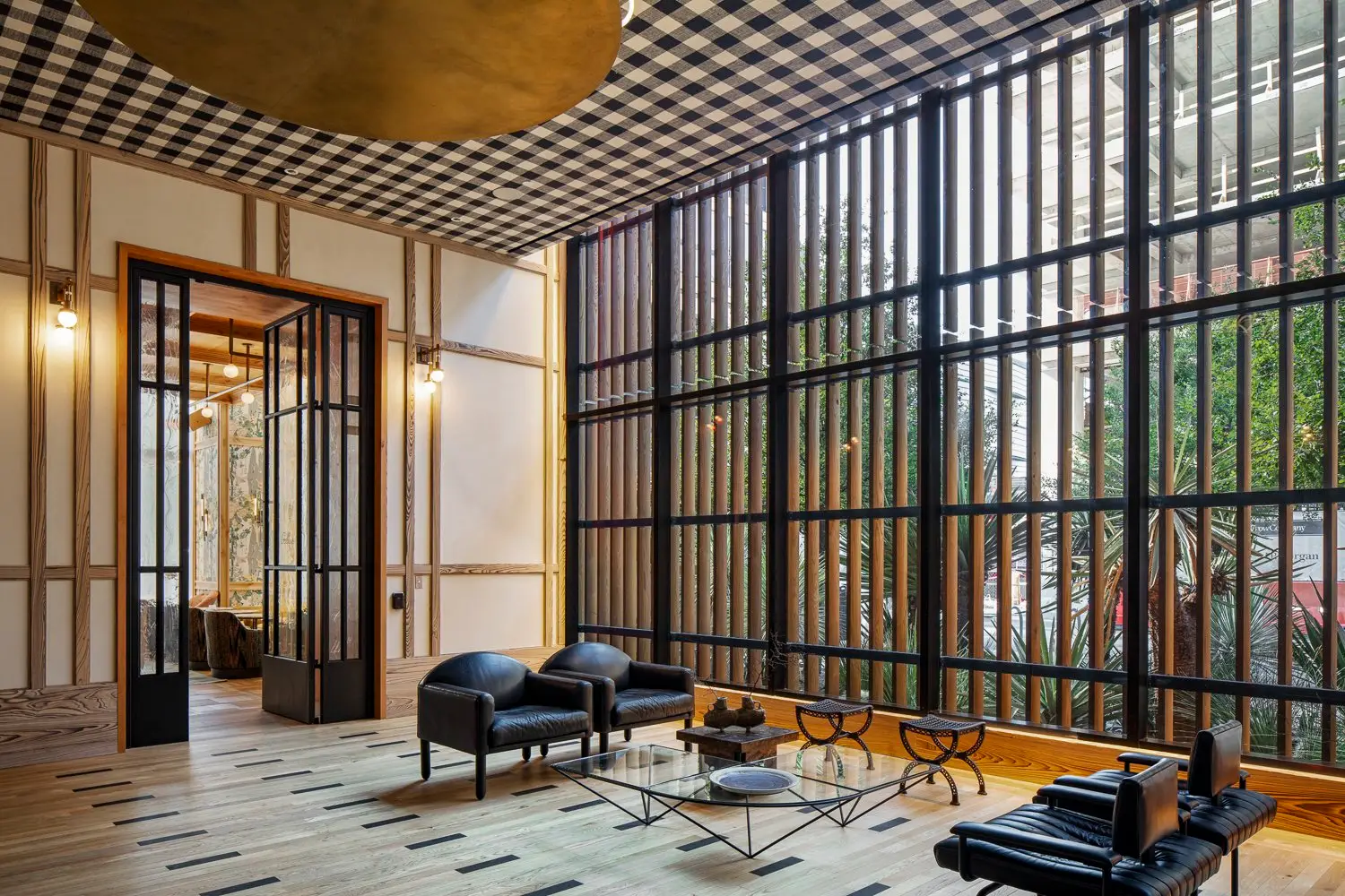 Austin Proper Hotel lobby lounge with a black-framed glass wall and a checkered ceiling