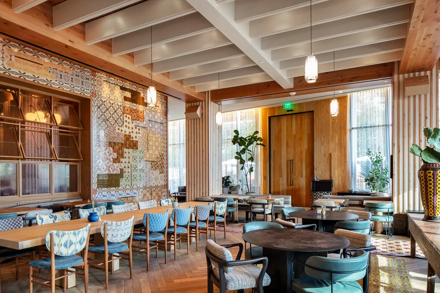 Austin Proper Hotel dining room with an exposed wood beam ceiling and a tile accent wall