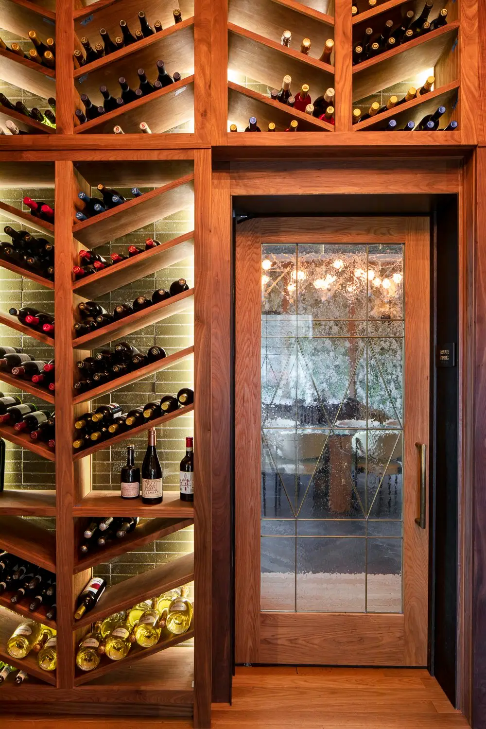 Austin Proper Hotel wine room with angled wine racks and a glass door