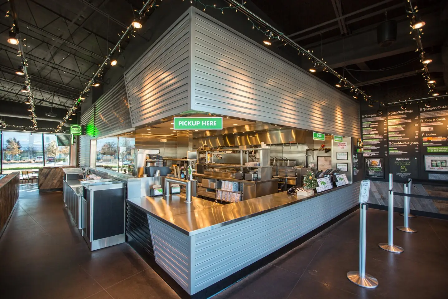 Shake Shack Domain interior order counter with a metal-clad canopy and queue posts