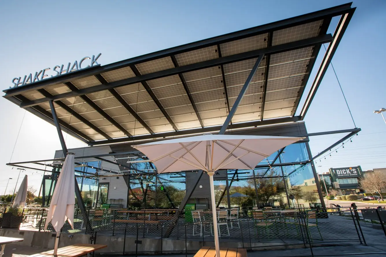 Shake Shack Domain patio canopy of steel framing over outdoor seating with the SHAKE SHACK sign
