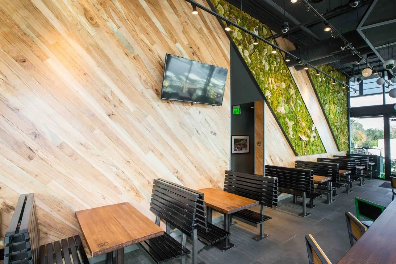 Shake Shack S. Lamar diagonal wood wall with a TV and booth seating