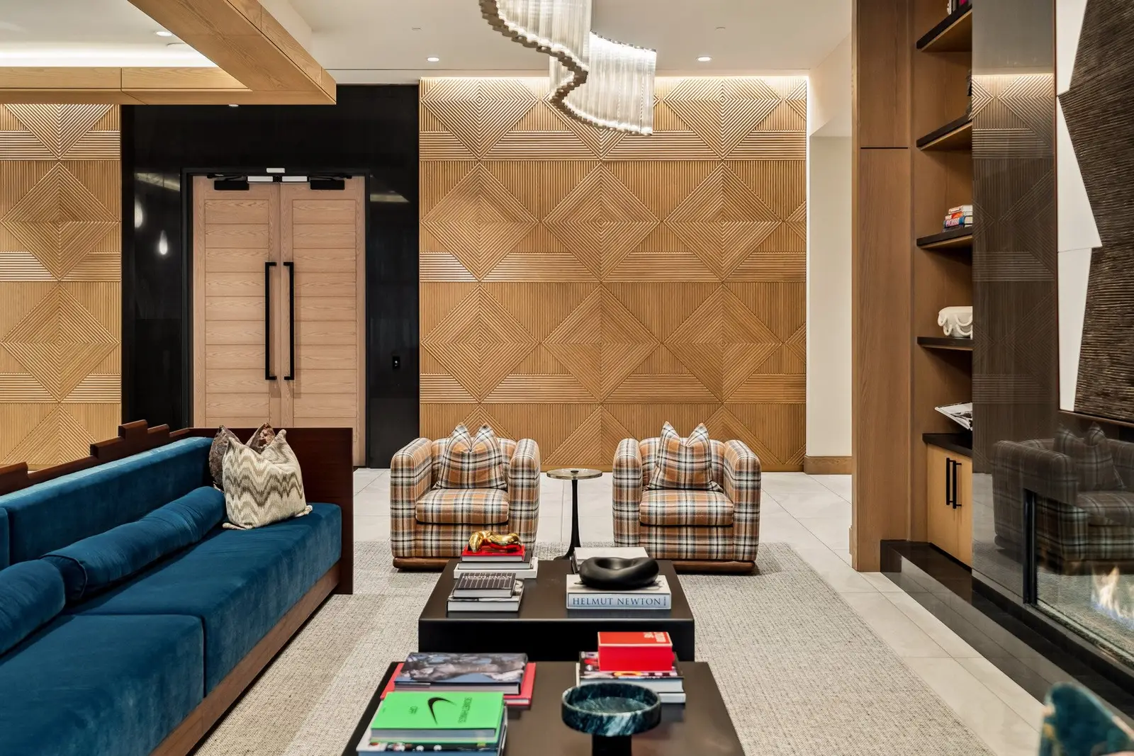 Sixth and Guadalupe lounge with a diamond-pattern wood wall, blue sofa and built-in shelving