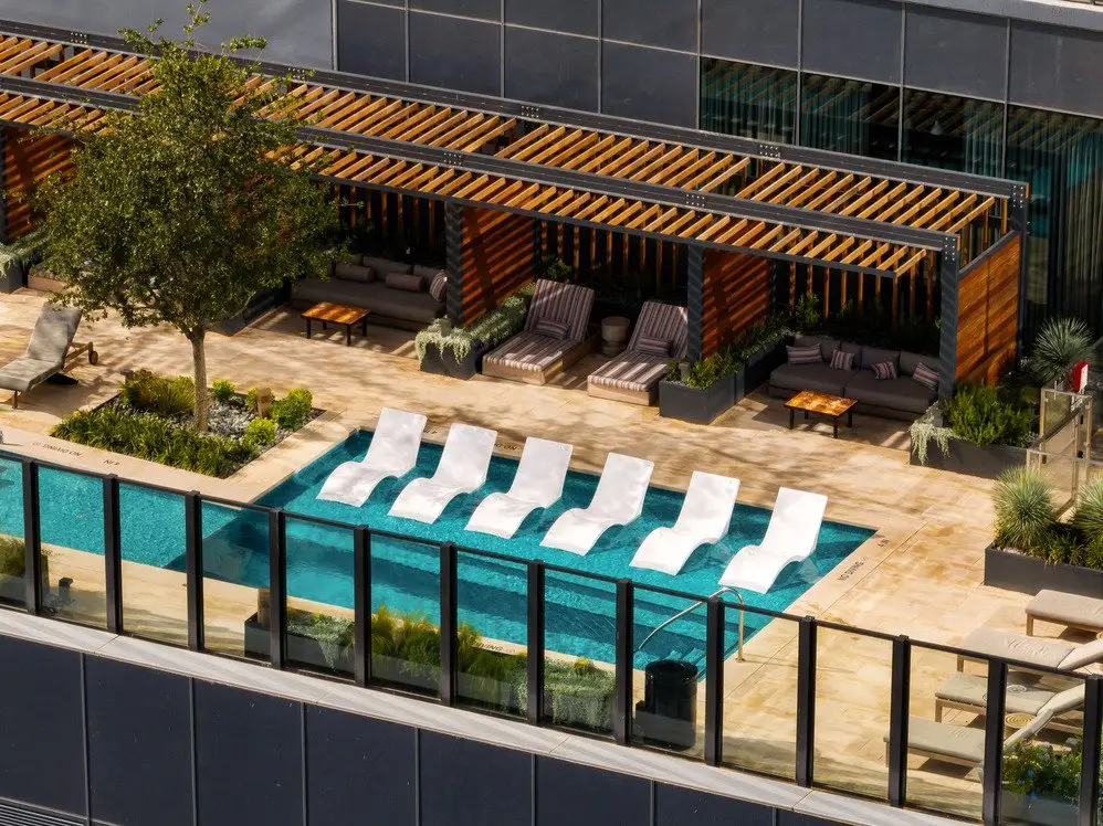 Sixth and Guadalupe pool deck seen from above with lounge chairs and a wood slat pergola
