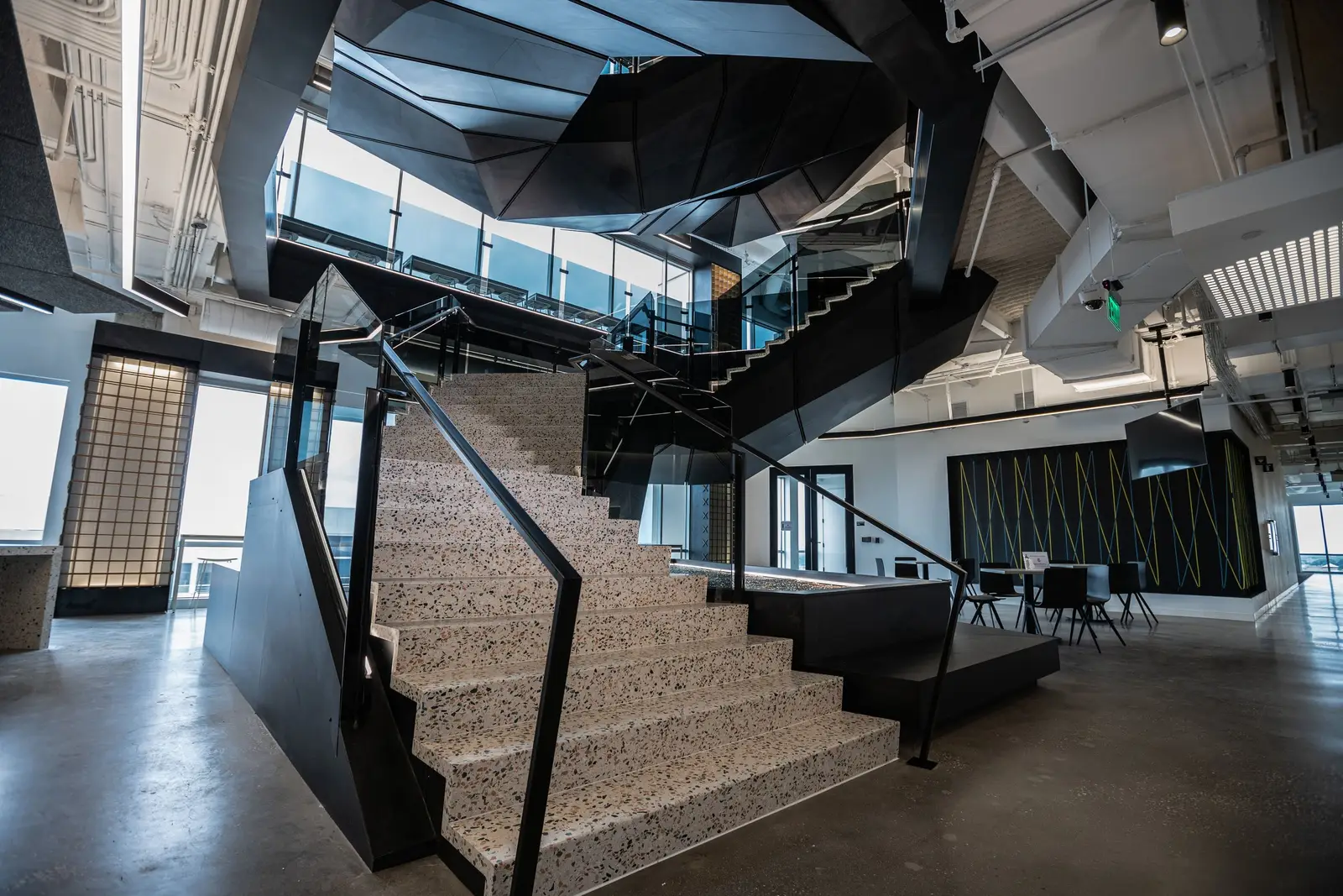 Splunk angular black metal stair with stone-look steps and a glass railing