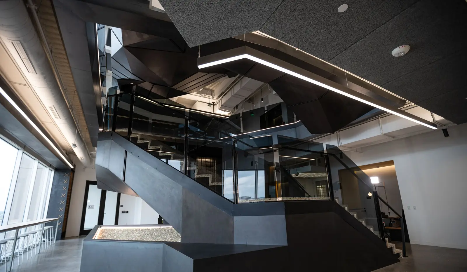 Splunk dark metal stair and lit ceiling feature in an open office