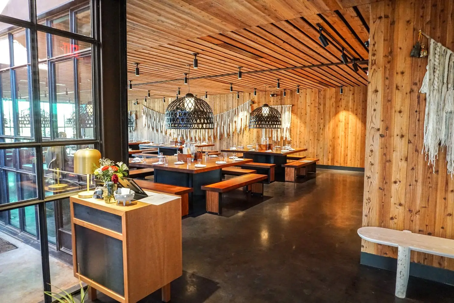 Sway Bee Caves restaurant with a wood slat ceiling, wood-clad columns and communal tables