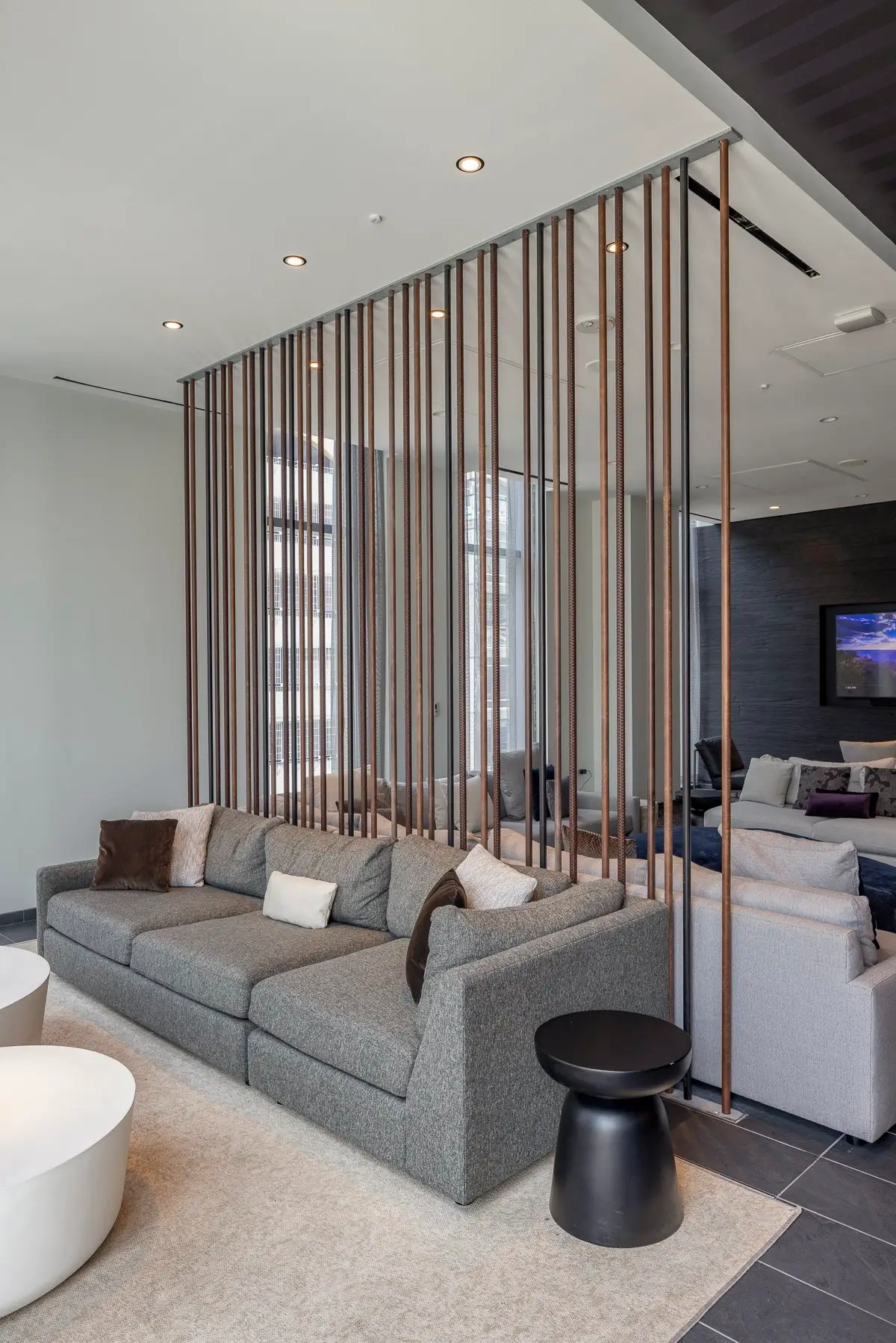 Thompson Hotel lounge with a gray sofa and a vertical wood slat divider