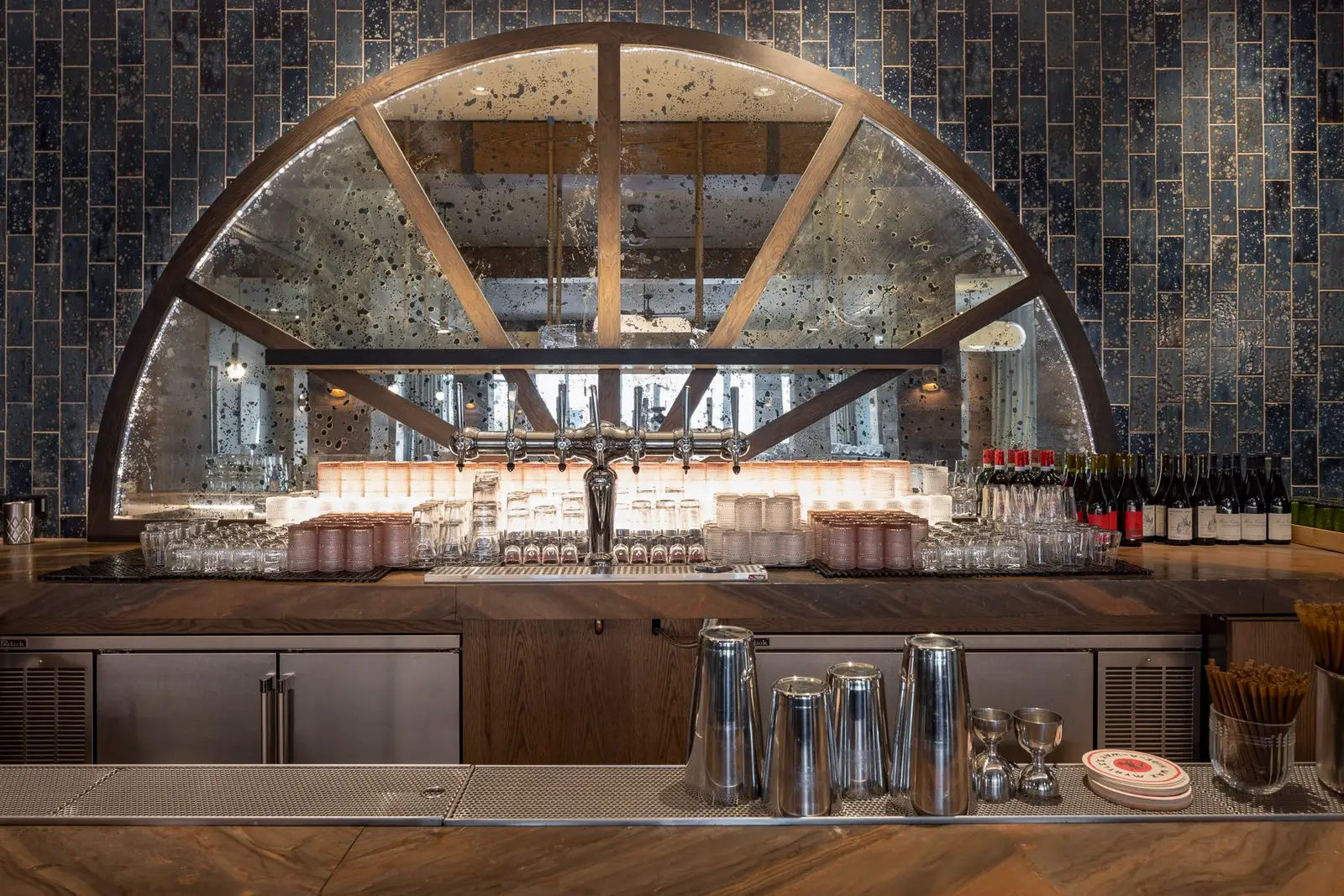 Thompson Hotel back bar with an arched window frame and blue tile wall
