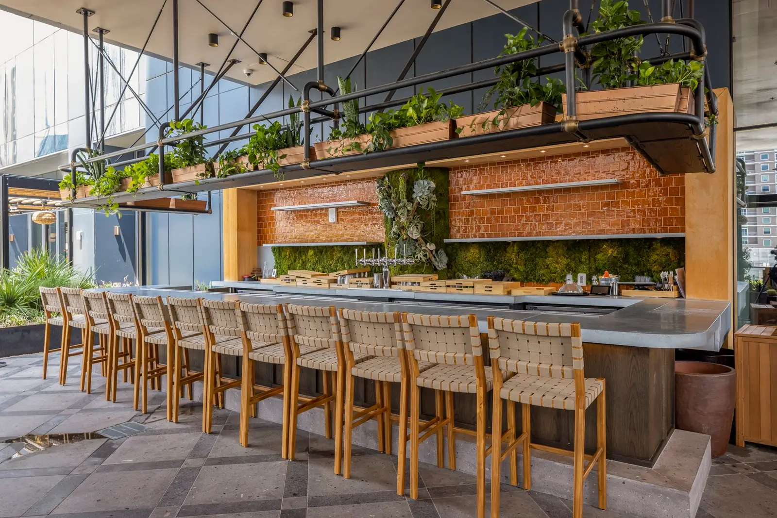 Thompson Hotel rooftop bar with wood stools and a hanging planter shelf