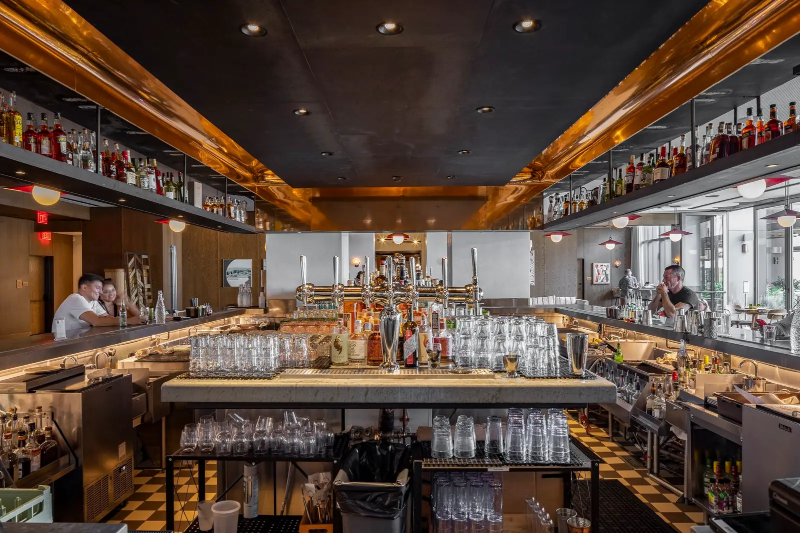 Thompson Hotel bar with a wood and steel ceiling frame and back-bar shelves