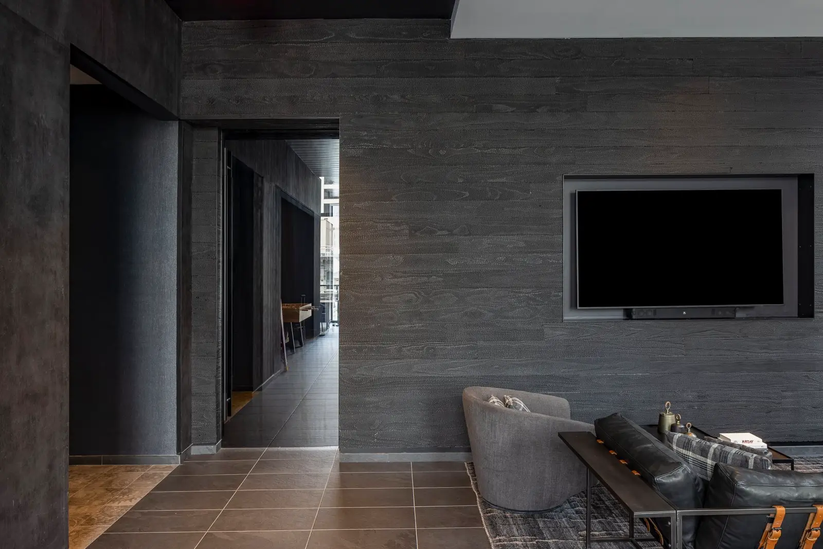 Thompson Hotel lounge with a gray wall, a TV and sofa seating