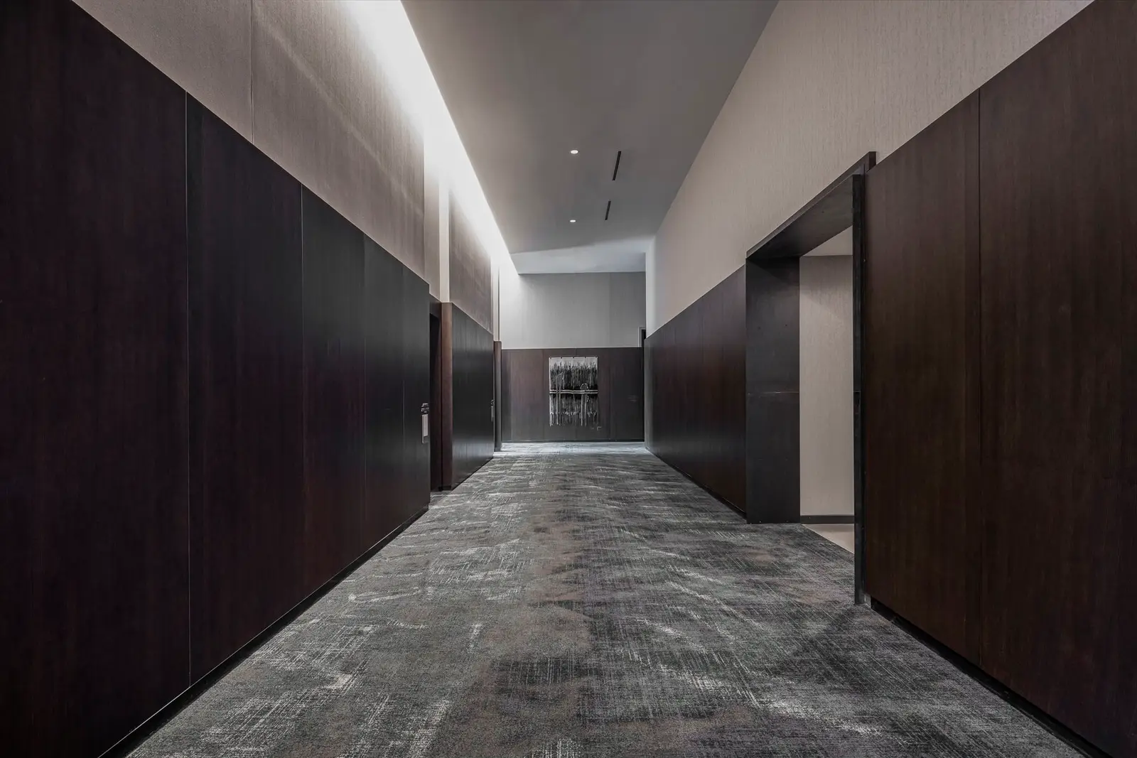 Thompson Hotel corridor with dark wood wall panels and a lit ceiling reveal