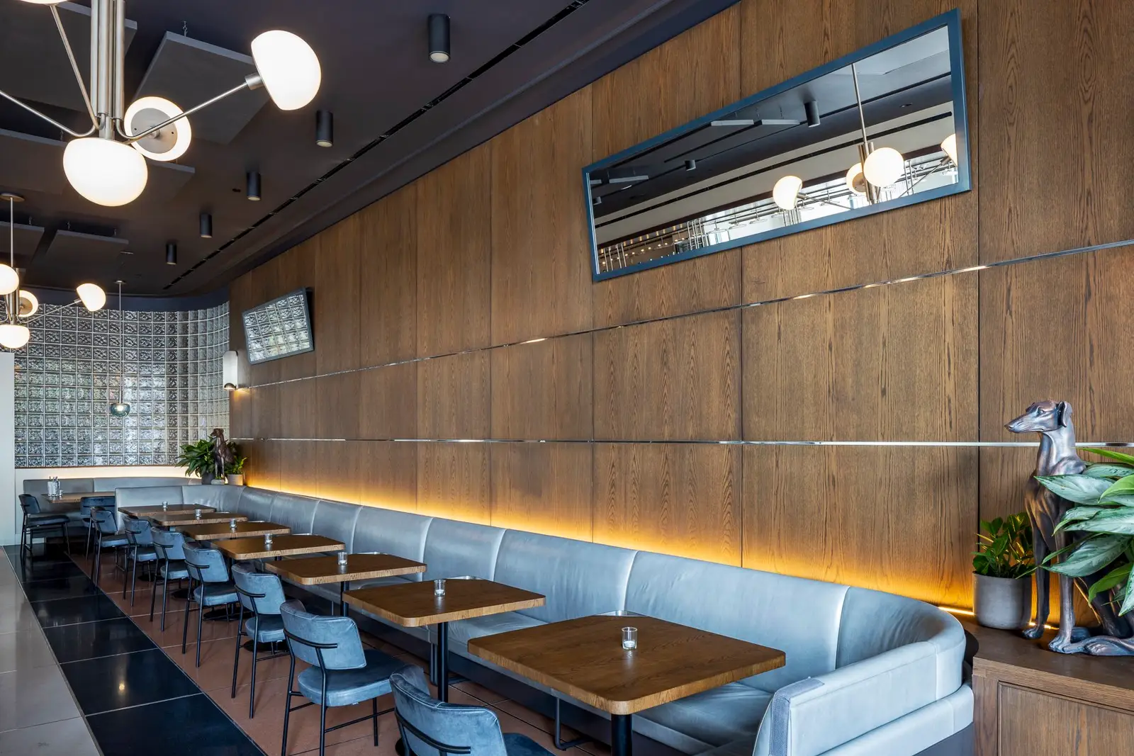 Thompson Hotel restaurant with a wood-paneled wall, banquette and tables