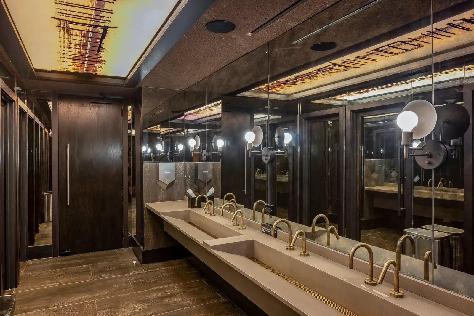 Thompson Hotel restroom with a long trough sink and mirrored wall