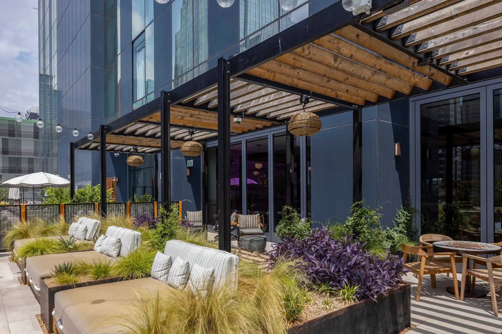 Thompson Hotel rooftop terrace with a wood and steel pergola and lounge seating