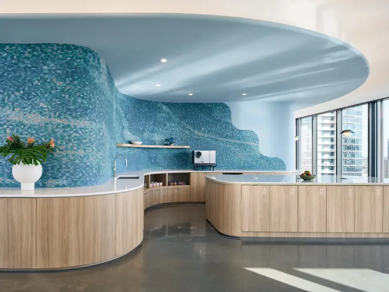 TikTok reception area with curved wood-front counters and a blue tile sculpted wall