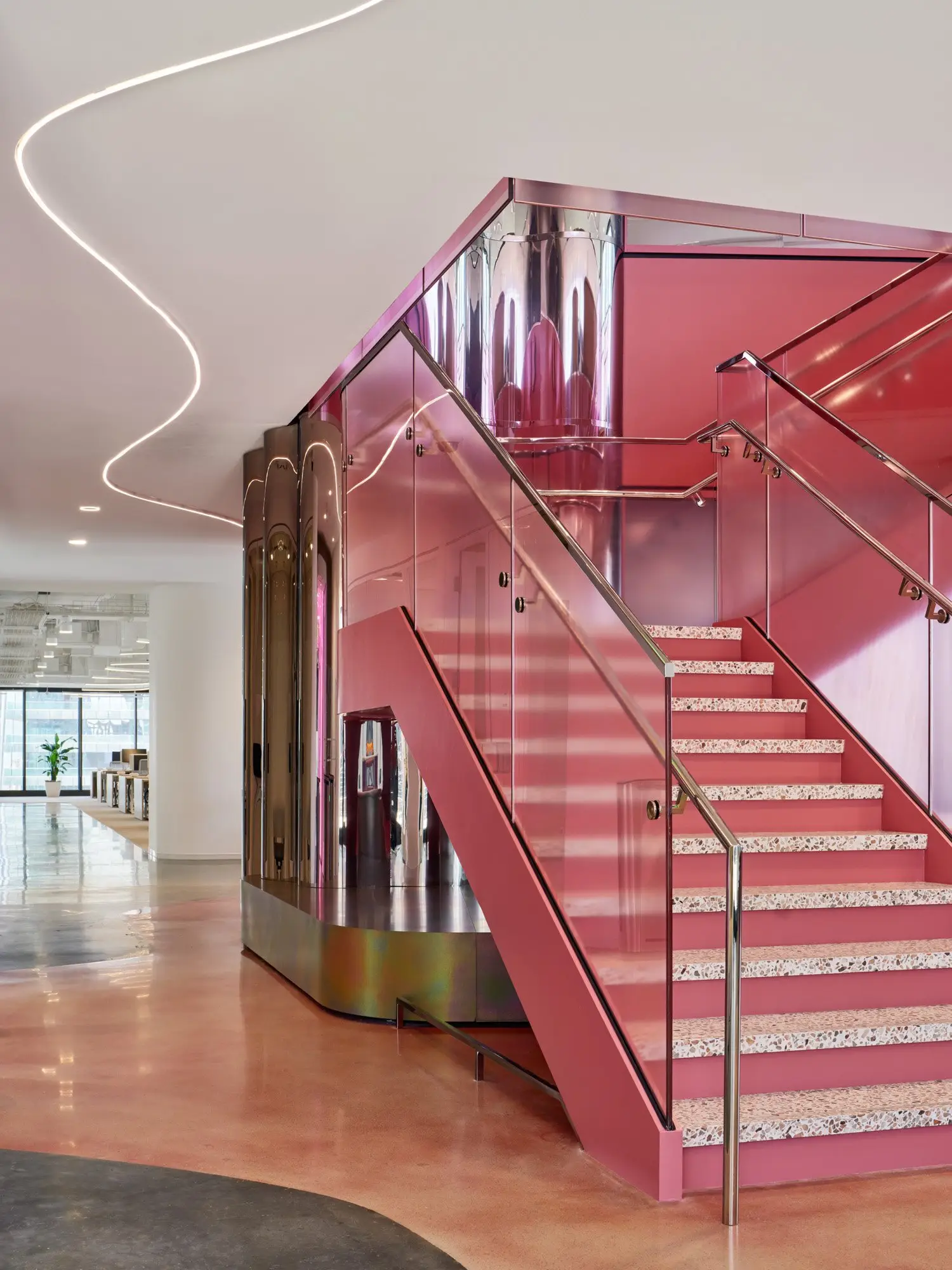 TikTok pink stair with glass railings and a polished metal enclosure