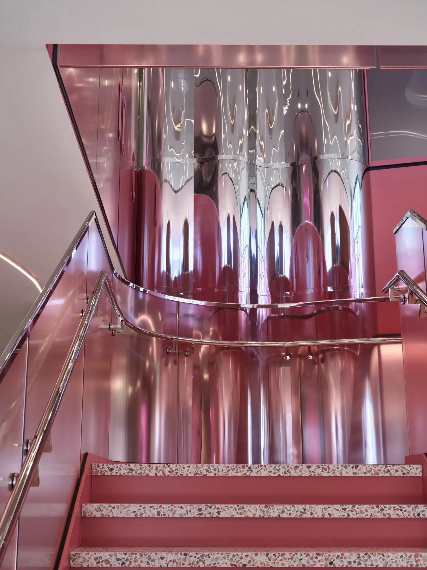 TikTok pink stair and polished metal detail seen from below