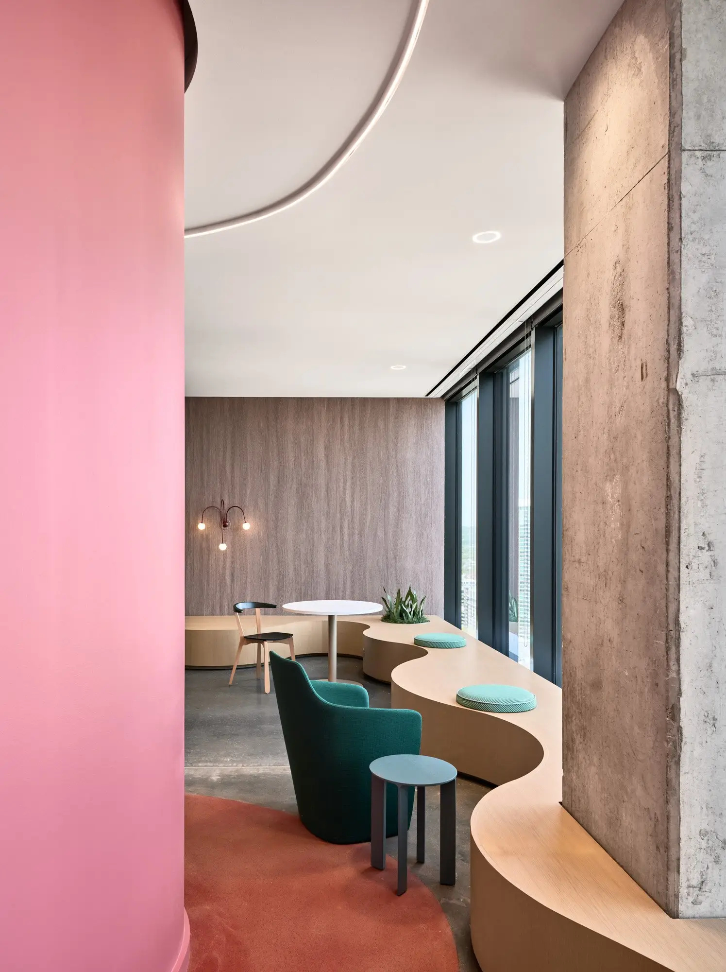 TikTok lounge seating along a curved wood bench beside a pink column