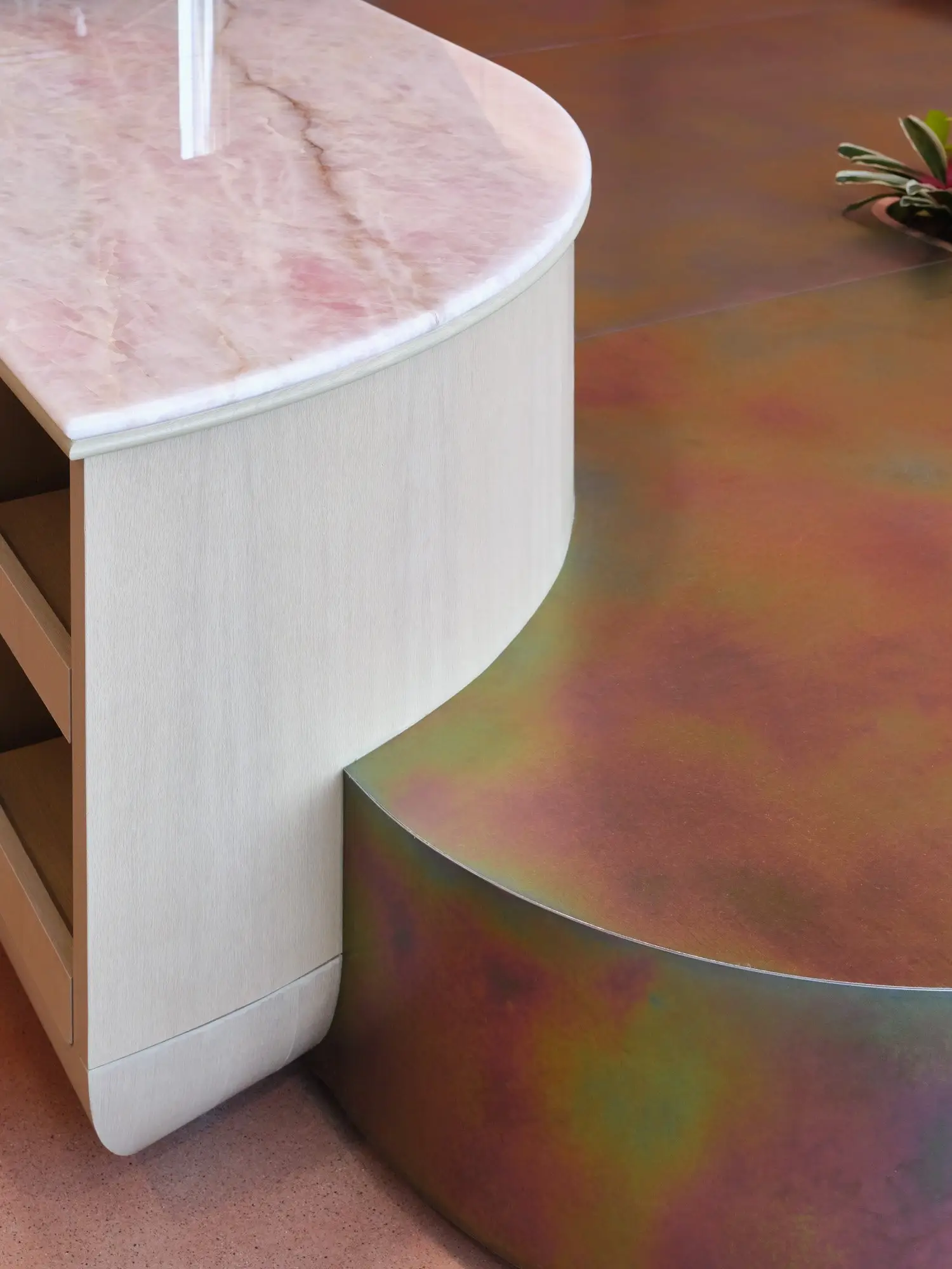 TikTok curved wood-front counter with a pink stone top beside a curved metal-clad base