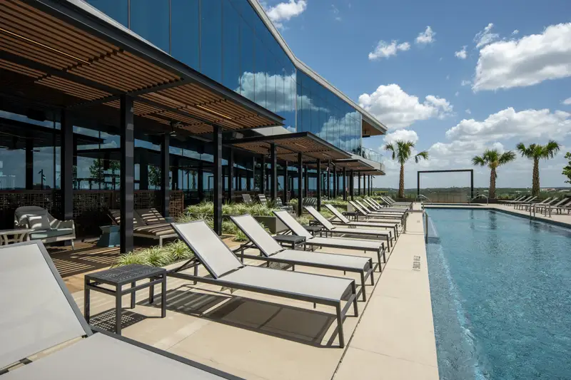 Travis Tower rooftop pool deck with lounge chairs under a wood slat shade structure