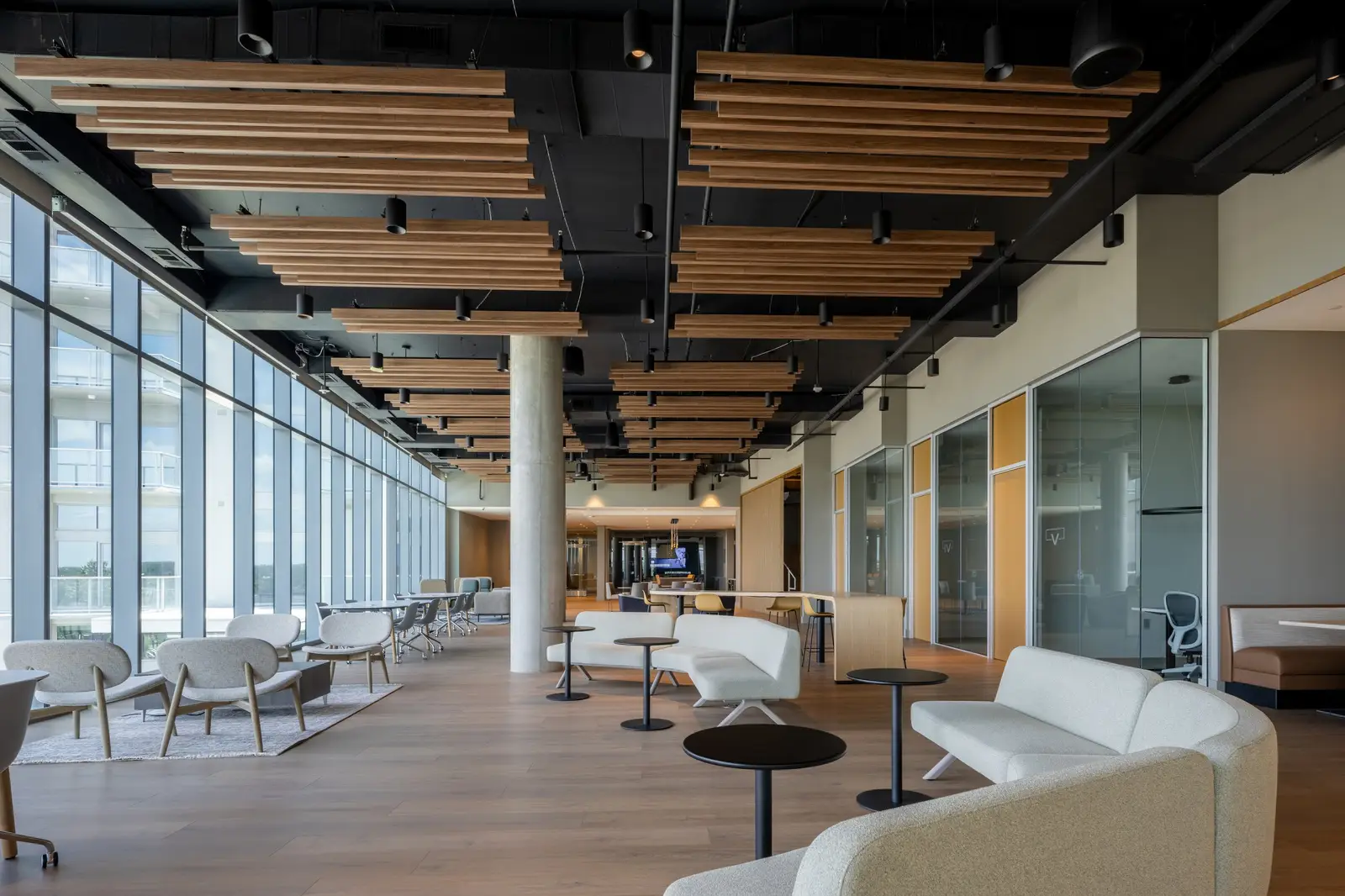 Travis Tower amenity lounge with wood slat ceiling, floor-to-ceiling glass and white sofas