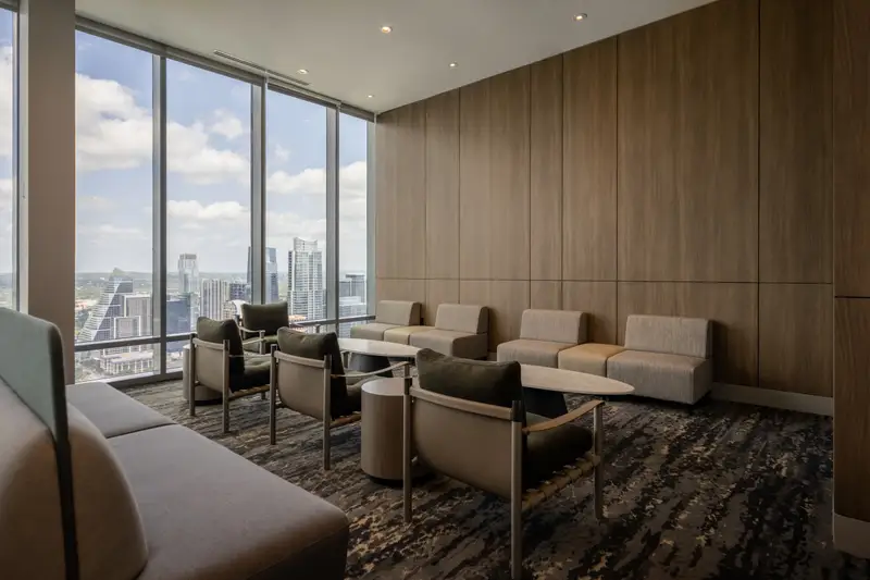 Travis Tower lounge with wood wall paneling, floor-to-ceiling windows and seating