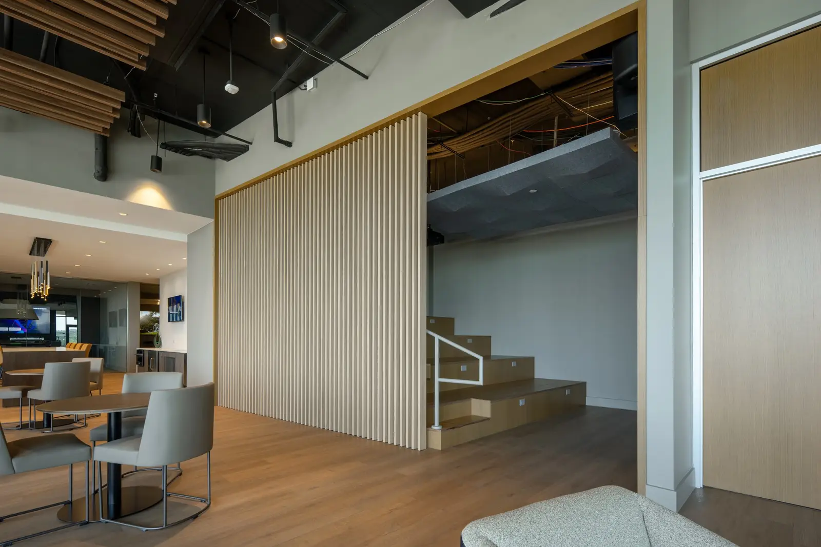Travis Tower open lounge with a vertical wood slat partition beside stairs