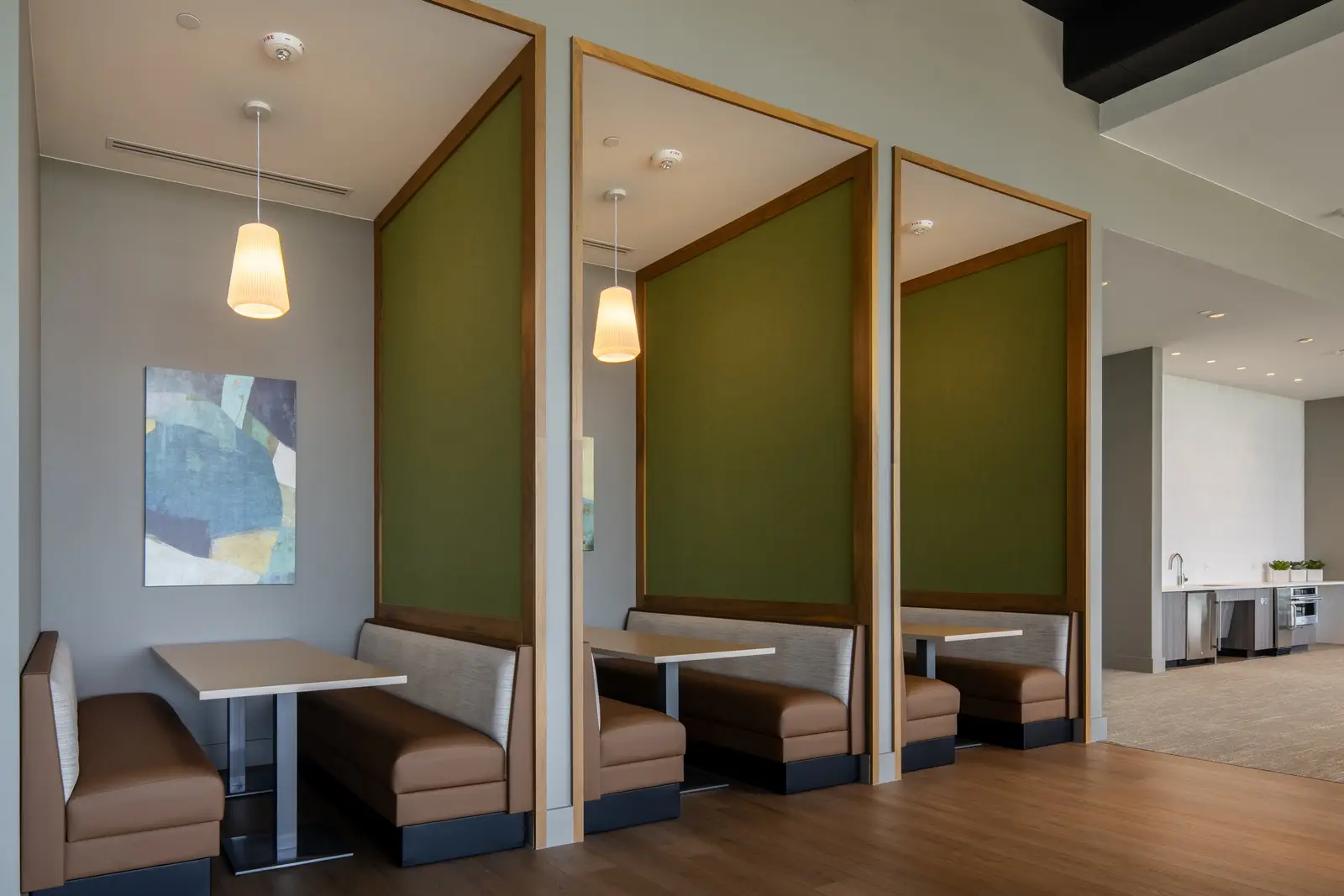 Travis Tower booth seating alcoves with wood-framed green panels