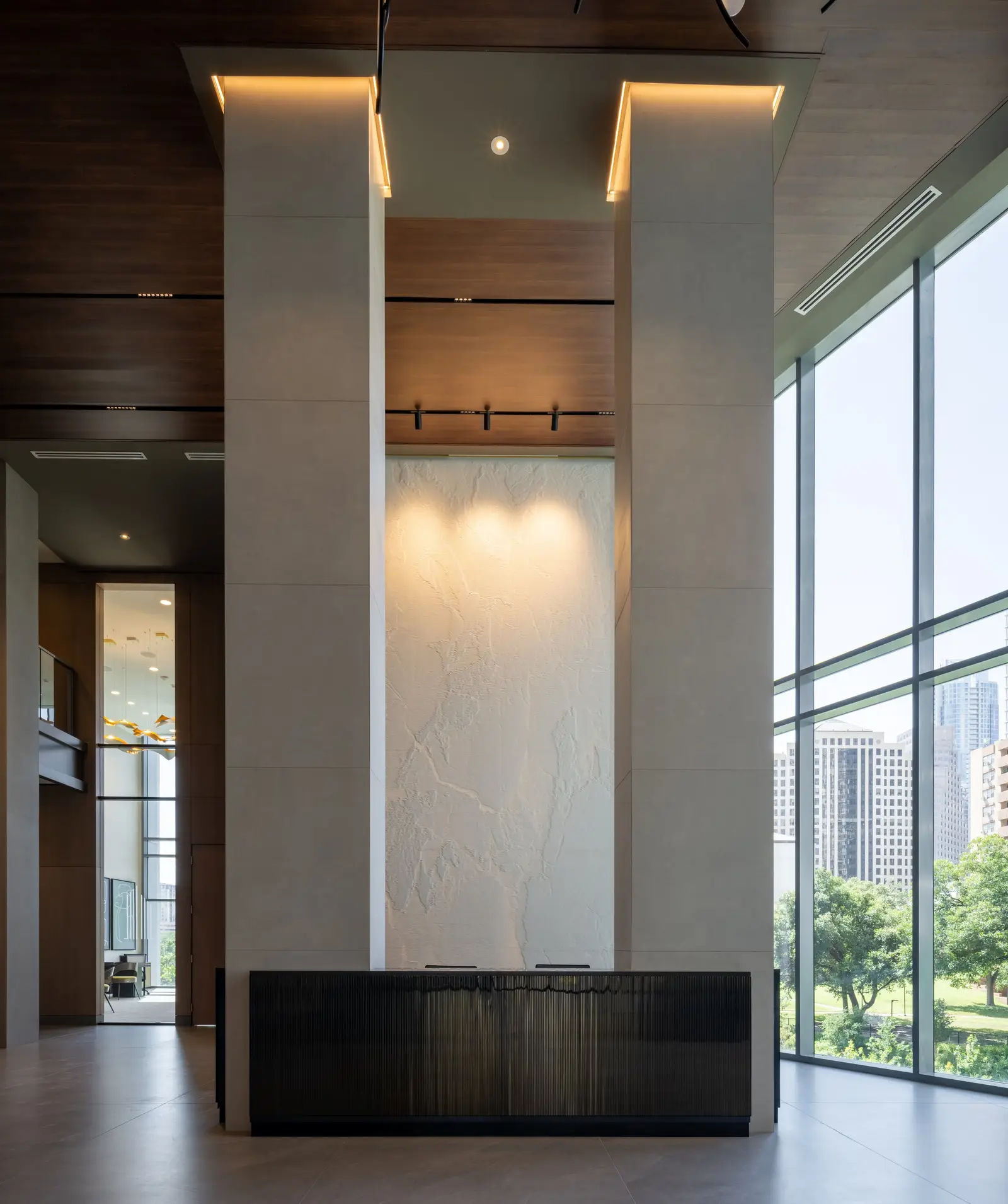 Travis Tower entry feature with two tall white columns, a backlit panel and a dark base