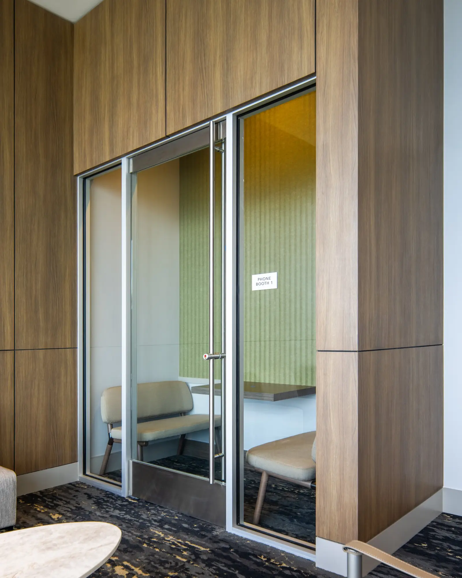 Travis Tower glass door to a small room framed by wood wall paneling