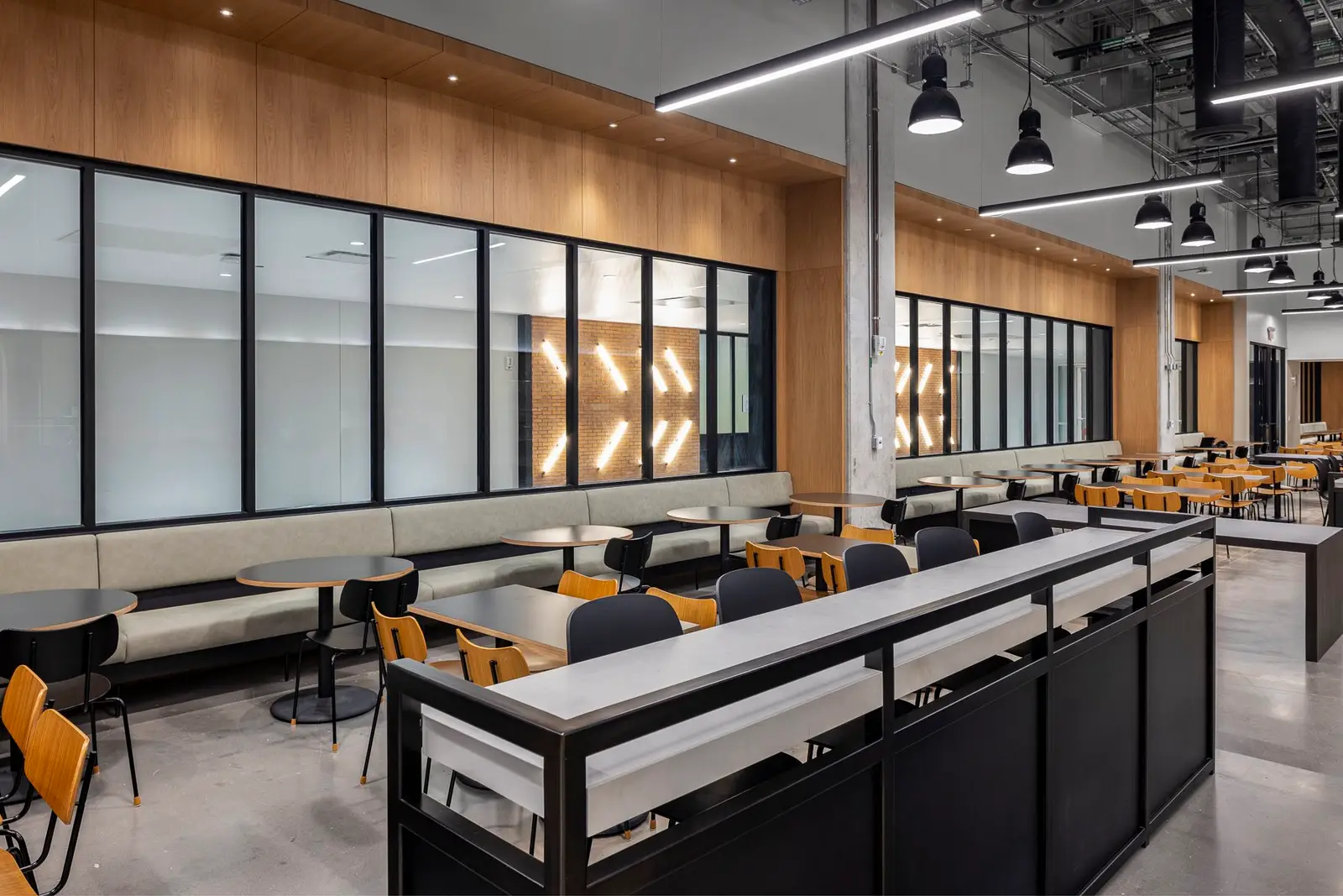 Undisclosed Project dining hall with a wood-paneled wall, bench seating and a long dark service counter