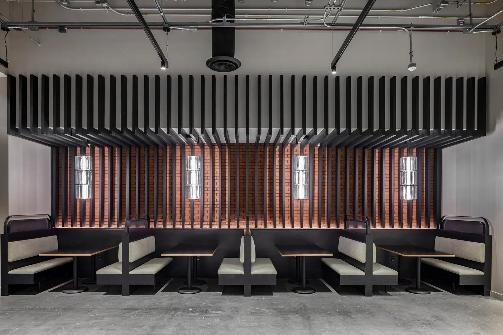Undisclosed Project booth seating below a black slat ceiling feature and wood slat wall