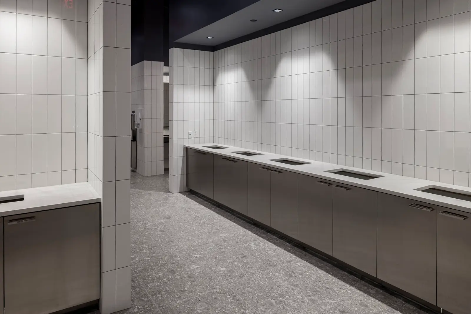 Undisclosed Project long counter with inset sinks along a white tile wall