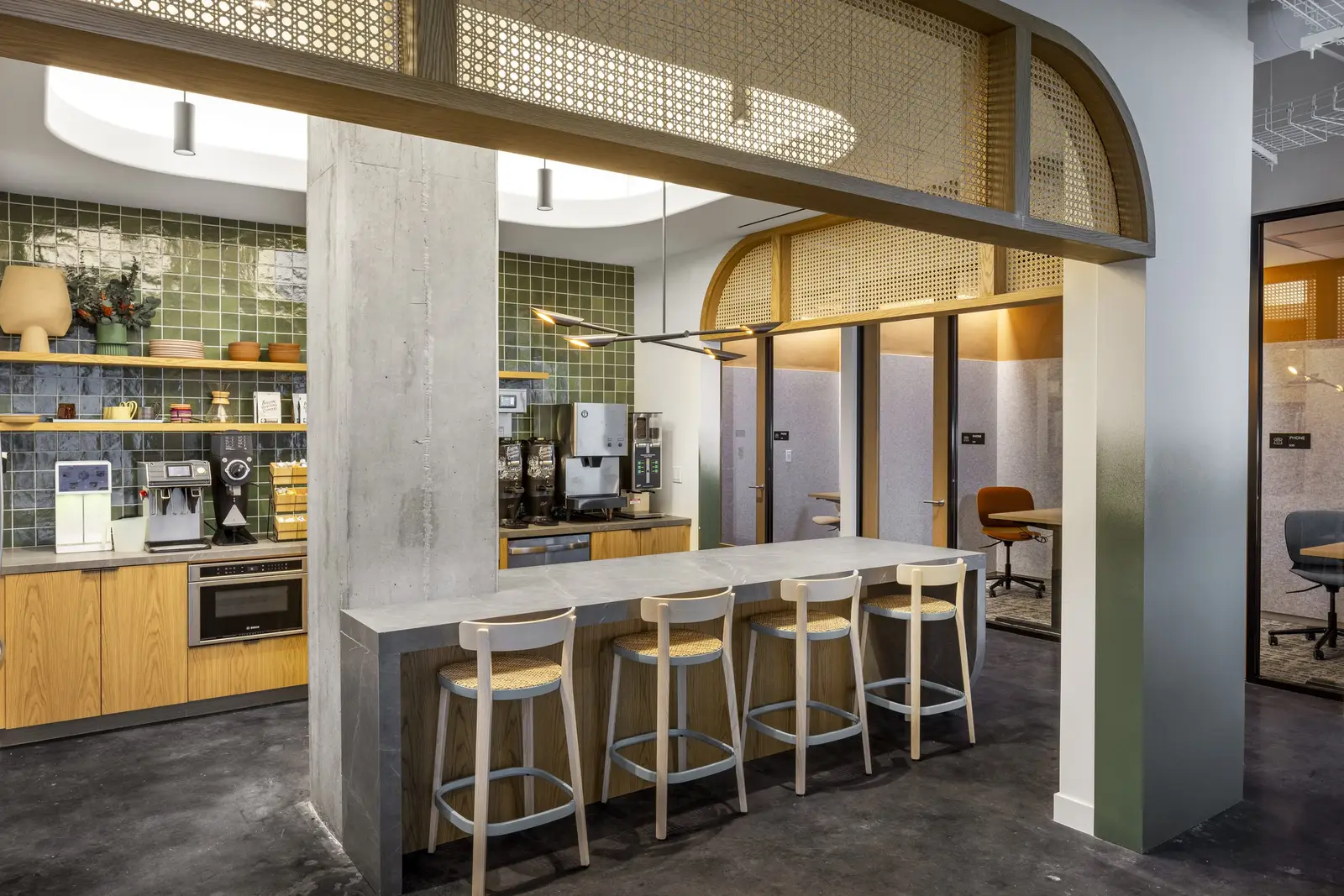 Unity kitchen with a stone island, wood cabinets and an arched wood opening