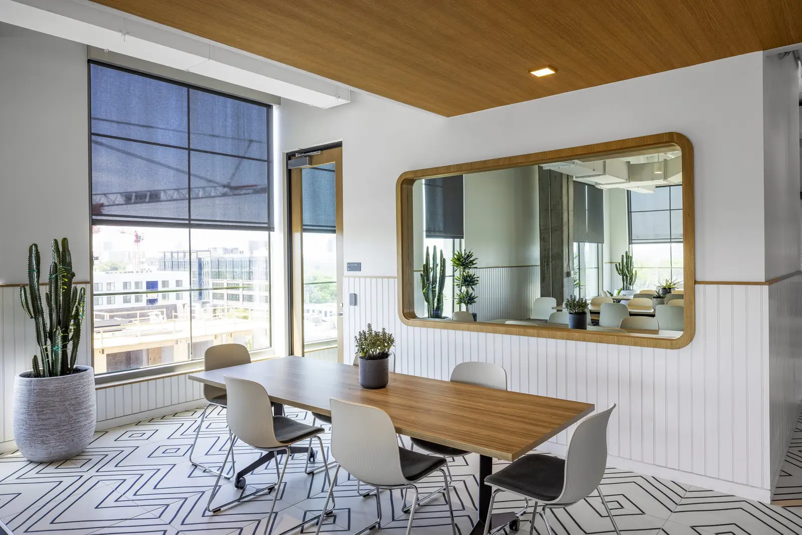 Unity meeting room with a wood table and a framed mirror